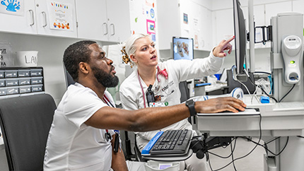 College nursing student learning on computer.