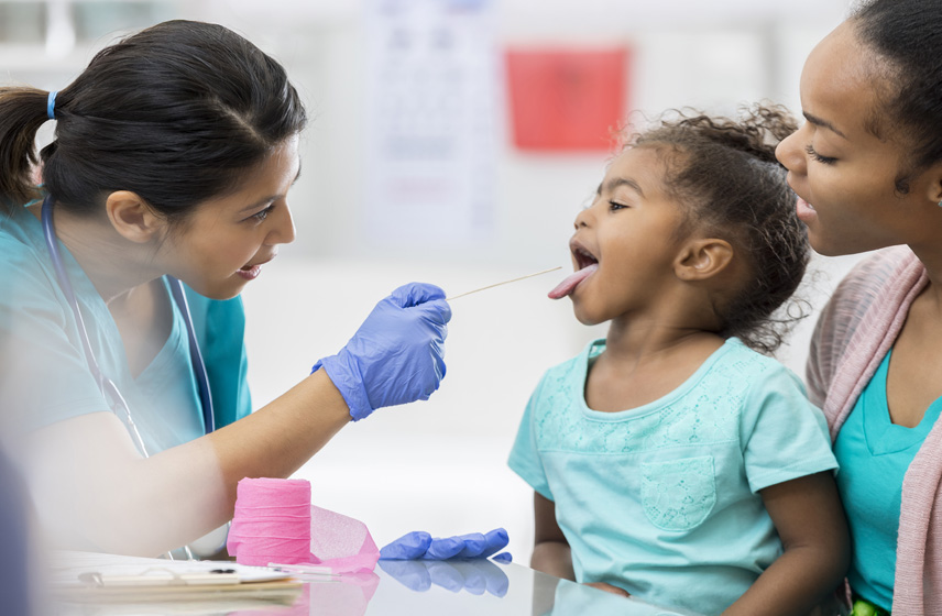 A Cleveland Clinic Caregiver examining a child's throat.