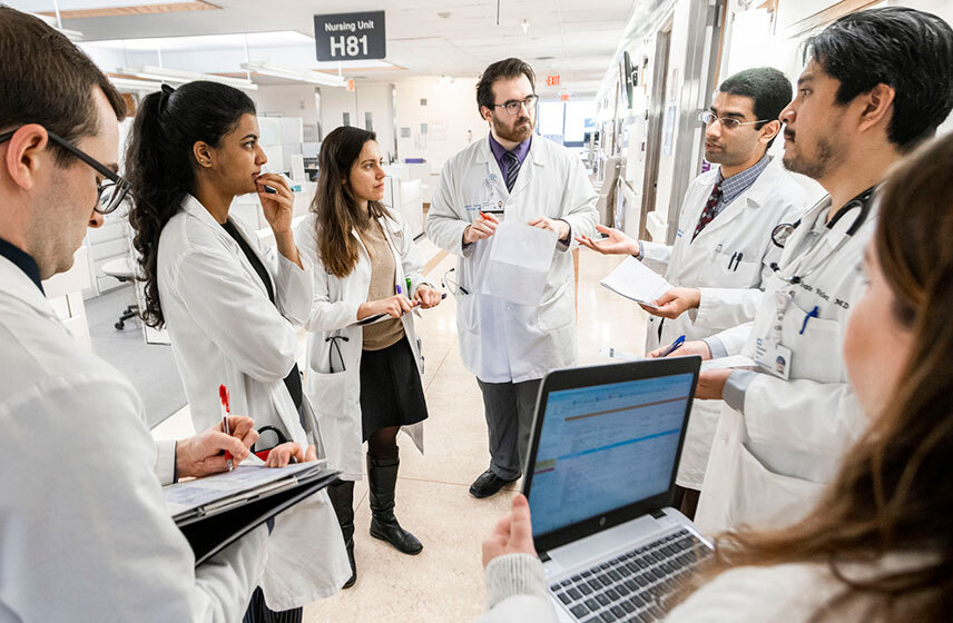 Residents standing in a circle listening to a Cleveland Clinic doctor.