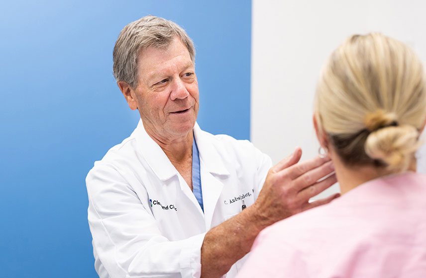 A Cleveland Clinic caregiver examining a patient's face.