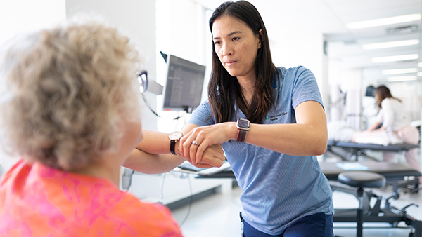 Caregiver looking at patient's wrist.